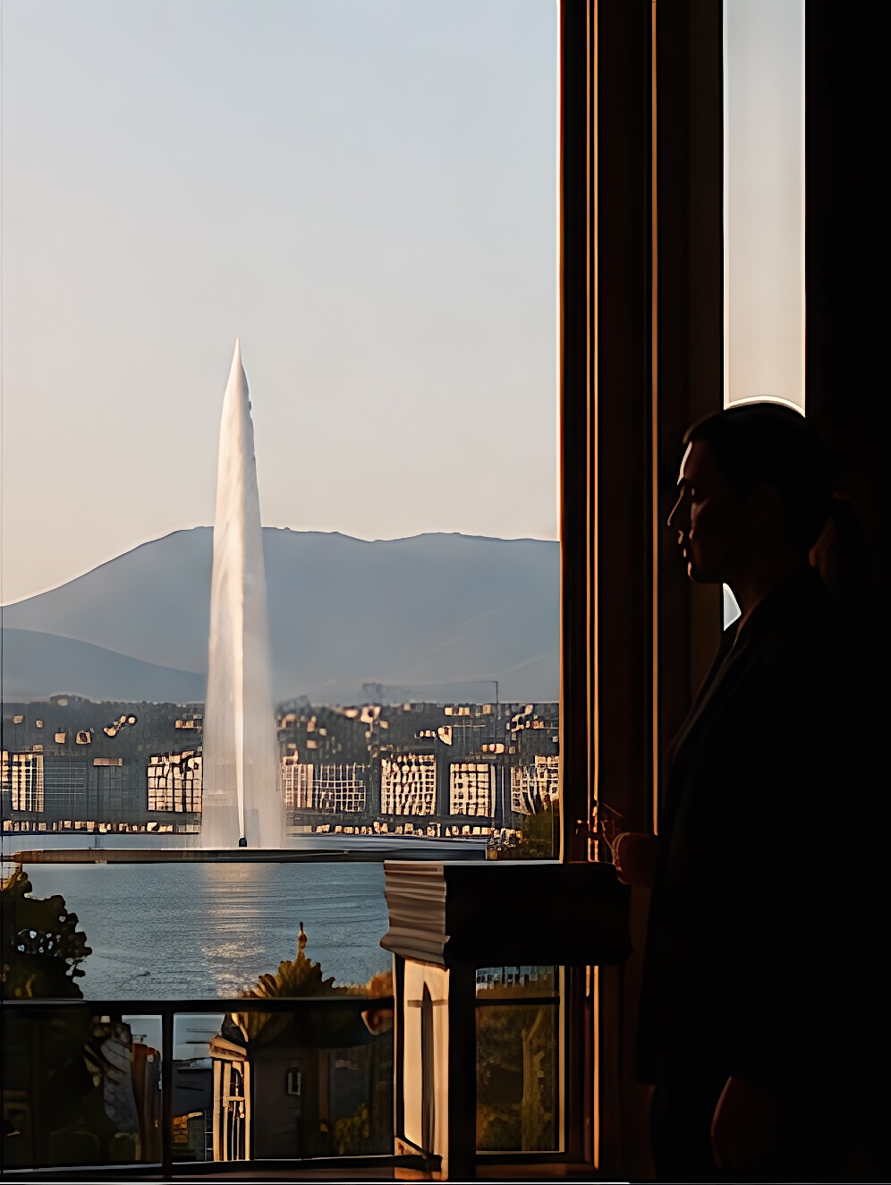 Le jet d'eau de Genève vu depuis une fenêtre, une silhouette en contre-jour
